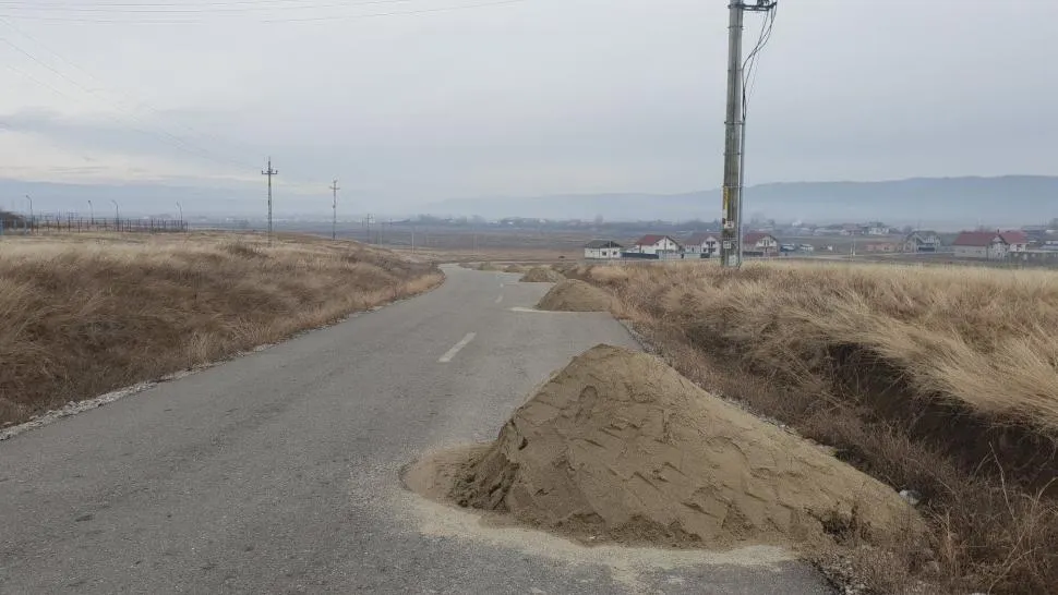 Dispar grămezile de nisip depozitate pe un drum din Gorj
